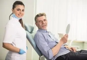 gentleman in dental chair with hygienist standing behind